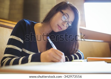 Focused student writing on notebook at the university