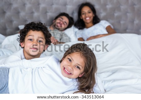 Family in bed with children in foreground