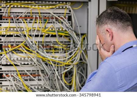 Stressed technician looking at open server locker at the data centre