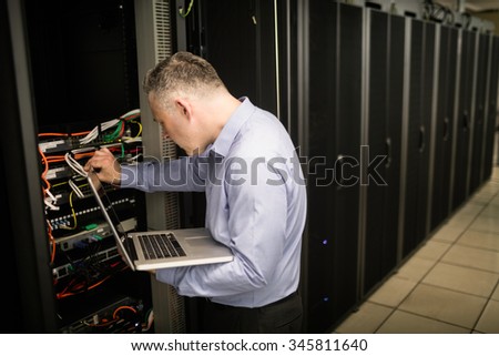 Technician looking at open server locker at the data centre