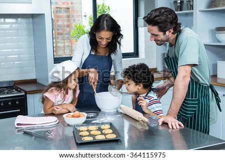 Happy family cooking biscuits together in kitchen at home