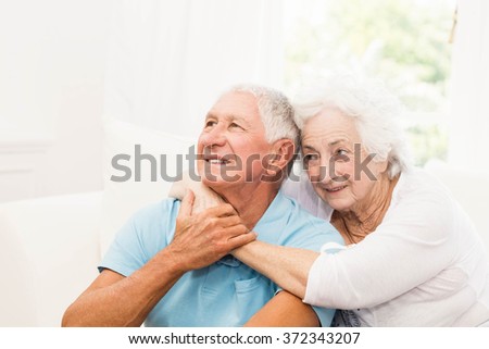Cute senior couple hugging on sofa