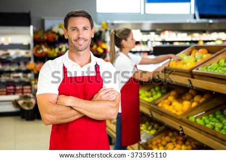 Smiling worker in front of colleague in grocery store