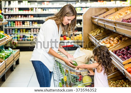 Mother and daughter doing shopping in grocery store