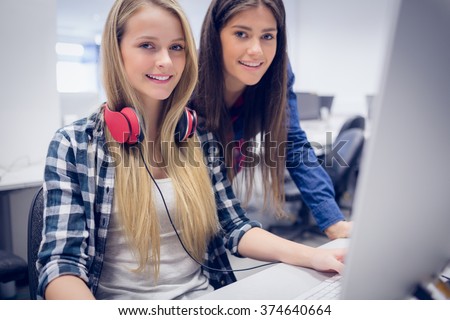 Smiling students using computer at university