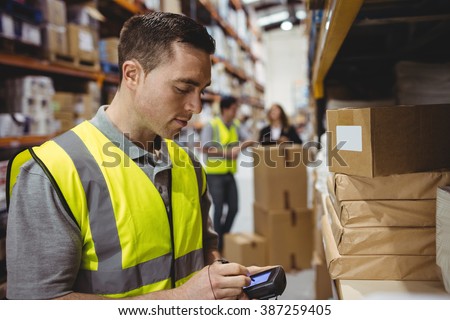 Warehouse worker scanning box in warehouse