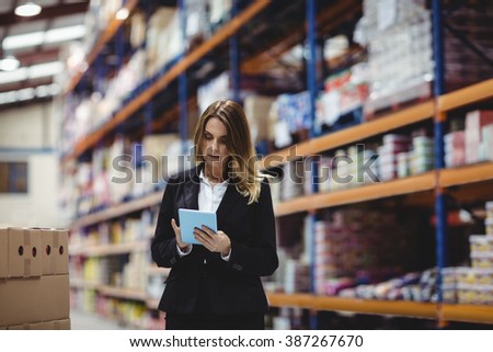 Businesswoman using tablet in warehouse