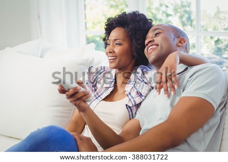 Happy couple watching tv on the sofa