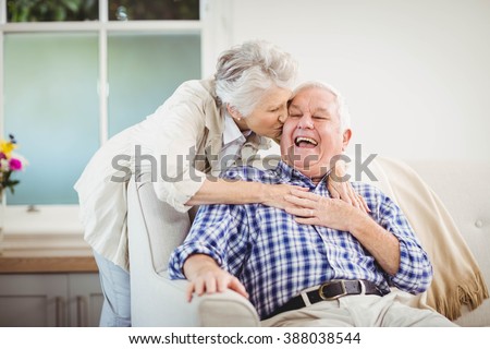 Senior woman embracing man in living room