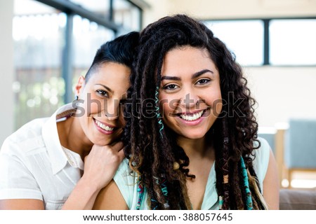 Smiling lesbian couple relaxing on sofa in living room