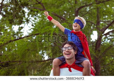 Father and son pretending to be superhero in park