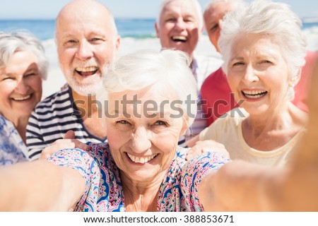 Senior friends taking selfie on the beach