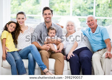 Portrait of smiling family with grandparents while sitting on sofa at home