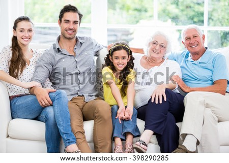 Portrait of smiling family with grandparents on sofa at home