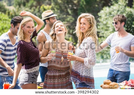 Group of friends enjoying at outdoors barbecue party near pool