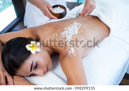 Woman enjoying a salt scrub massage at spa