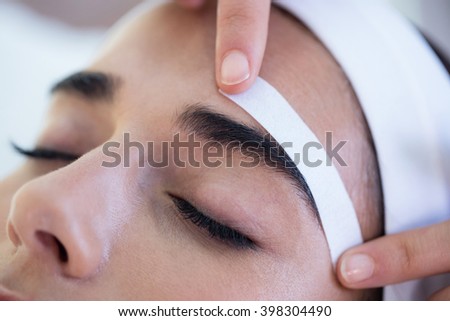 Woman getting her eyebrows shaped at spa