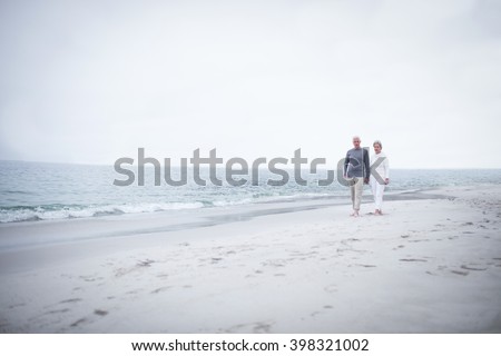 Senior couple walking on the beach on a sunny day