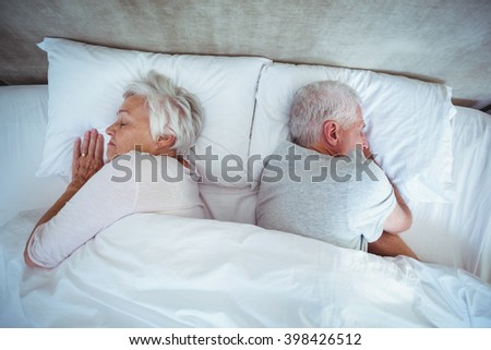 Overhead view of senior couple sleeping on bed
