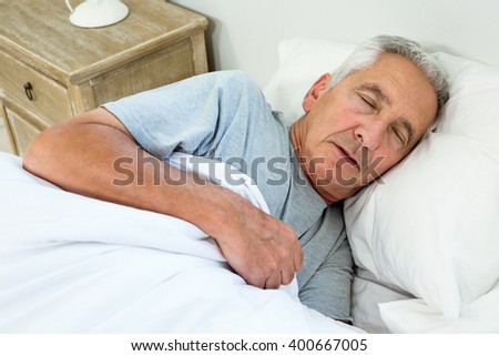 High angle view of old man sleeping on bed at home