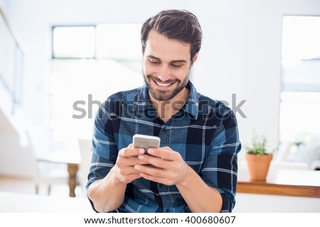 Happy man using mobile phone at home