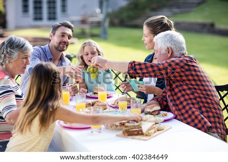 Happy family having lunch in the garden on a sunny day