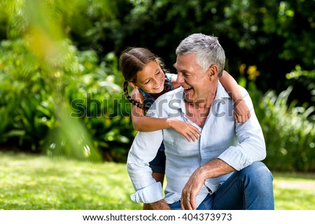 Happy grandfather and grandaughter playing at yard