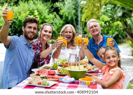 Happy family having breakfast at table in yard