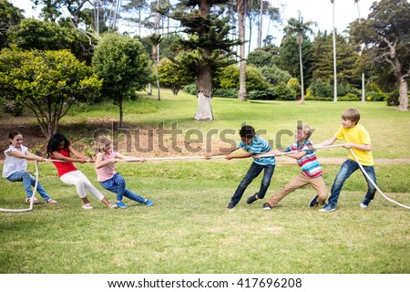 Children pulling a rope in tug of war in the park