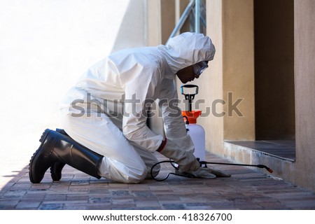 Side view of a man doing pest control at home
