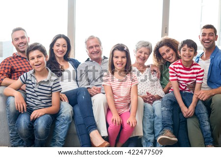 Portrait of happy family sitting on sofa in their living room