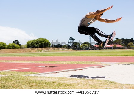 Athlete performing a long jump during a competition