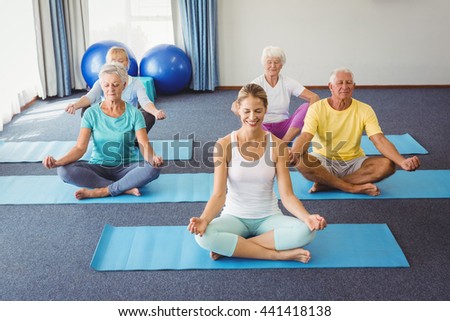 Seniors relaxing in lotus position during fitness class