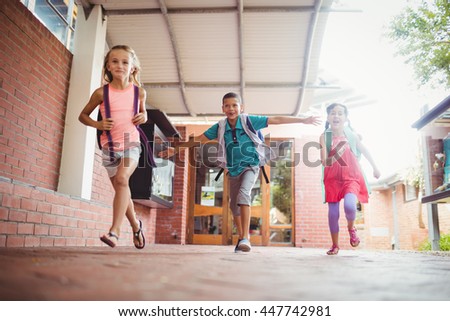 Three kids running in the playground on a sunny day