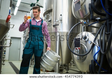 Brewery holding keg and testing beer at brewery factory