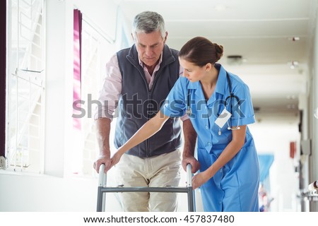 Nurse helping senior man with walking aid in a retirement home