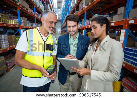 Warehouse team discussing with digital tablet in warehouse