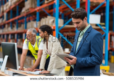 Warehouse managers and worker working together in warehouse office
