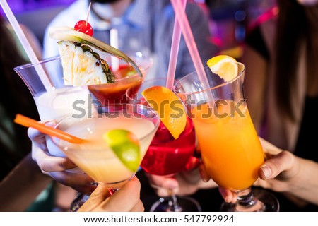 Group of friends toasting cocktail at bar counter in bar