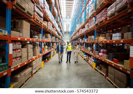 Front view of team is looking shelves and walking in a warehouse