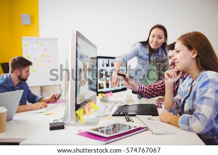 Business people working with computers at desk in creative office