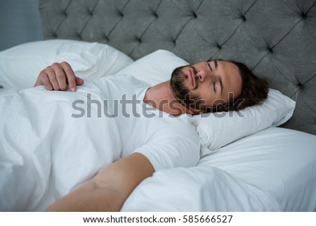 Man sleeping on his bed in bedroom at home