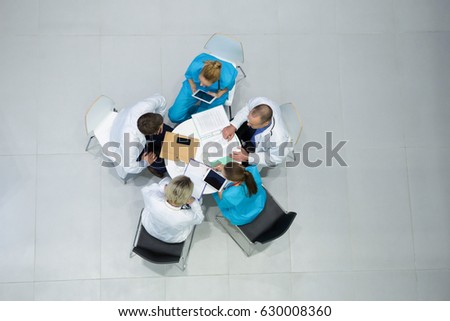 High angle view of doctors and surgeons interacting with each other in meeting at hospital