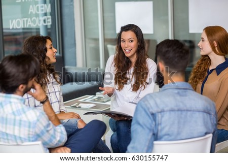 Male and female executives interacting with each other during meeting in office