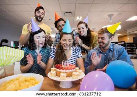 Creative business team celebrating colleagues birthday in office