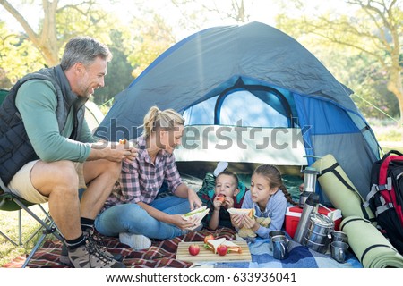 Family having snacks outside the tent at campsite