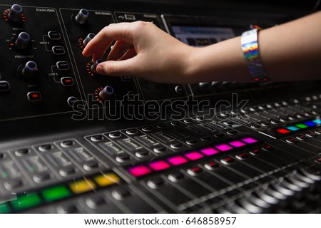 Hand of female audio engineer using sound mixer in recording studio