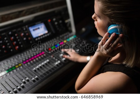 Female audio engineer using sound mixer in recording studio