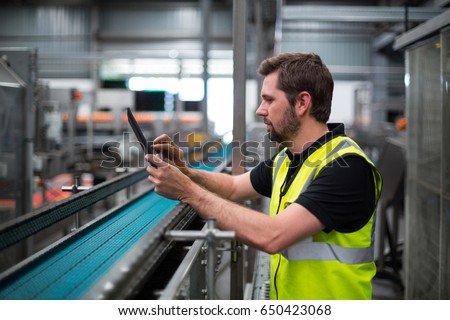 Attentive factory worker using a digital tablet in factory