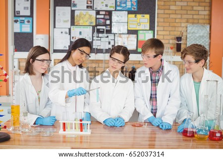 Attentive school kids doing a chemical experiment in laboratory at school